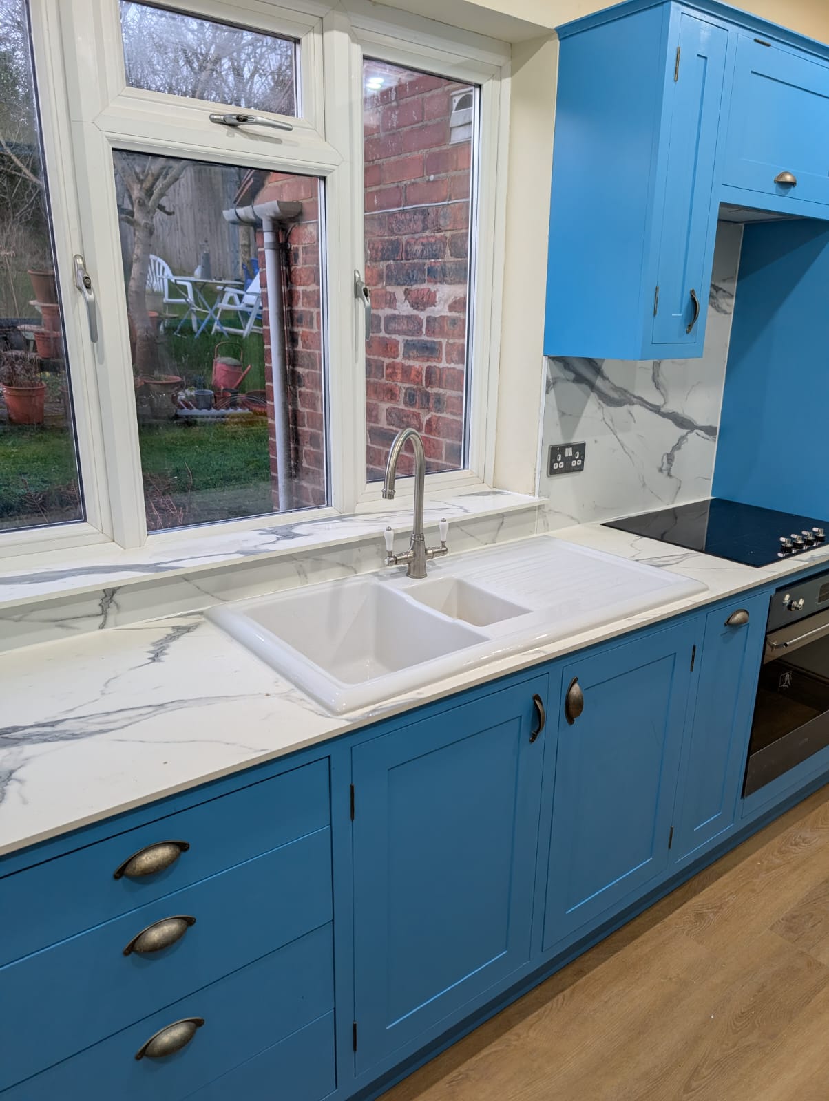 Blue handmade kitchen sink run with marble-effect worktop