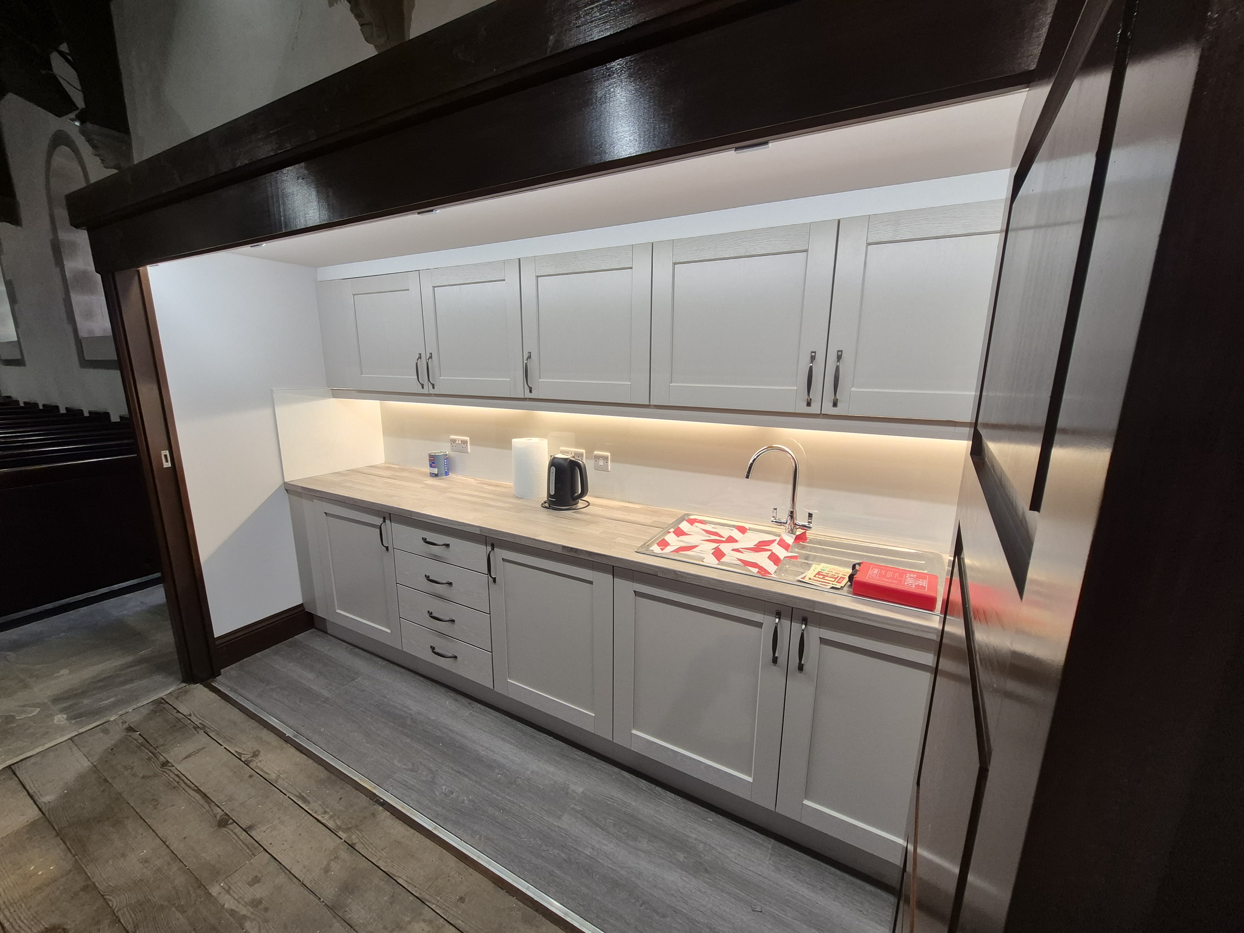 Grey kitchen run with sink and under-cabinet lighting