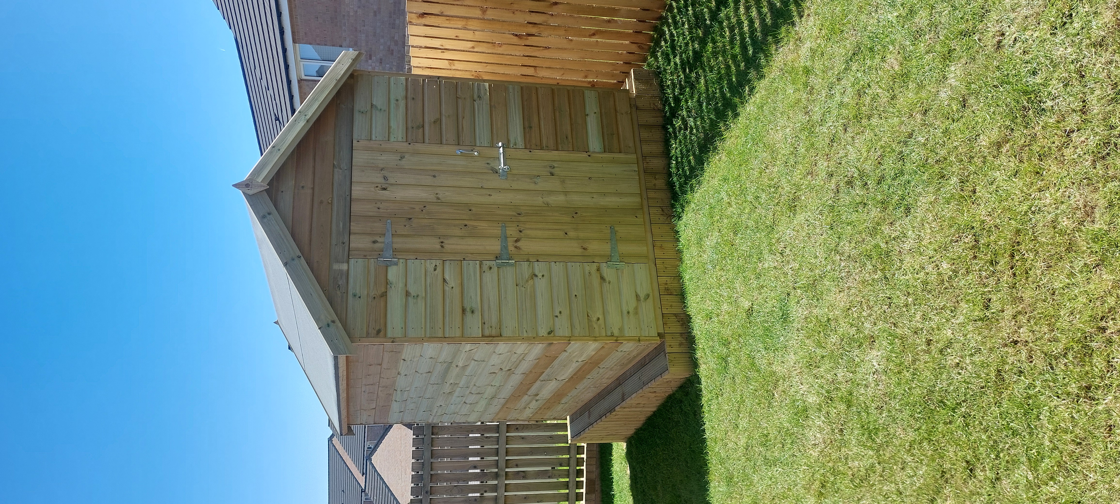 Timber garden shed with double doors on a lawn